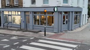 Outside view of Elizavet's clinic on Belsize Road in London - painted in grey with plants in the windows