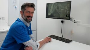 Veterinary surgeon Dr Dario Ambrogio at his desk in front of a screen showing an animal x-ray.